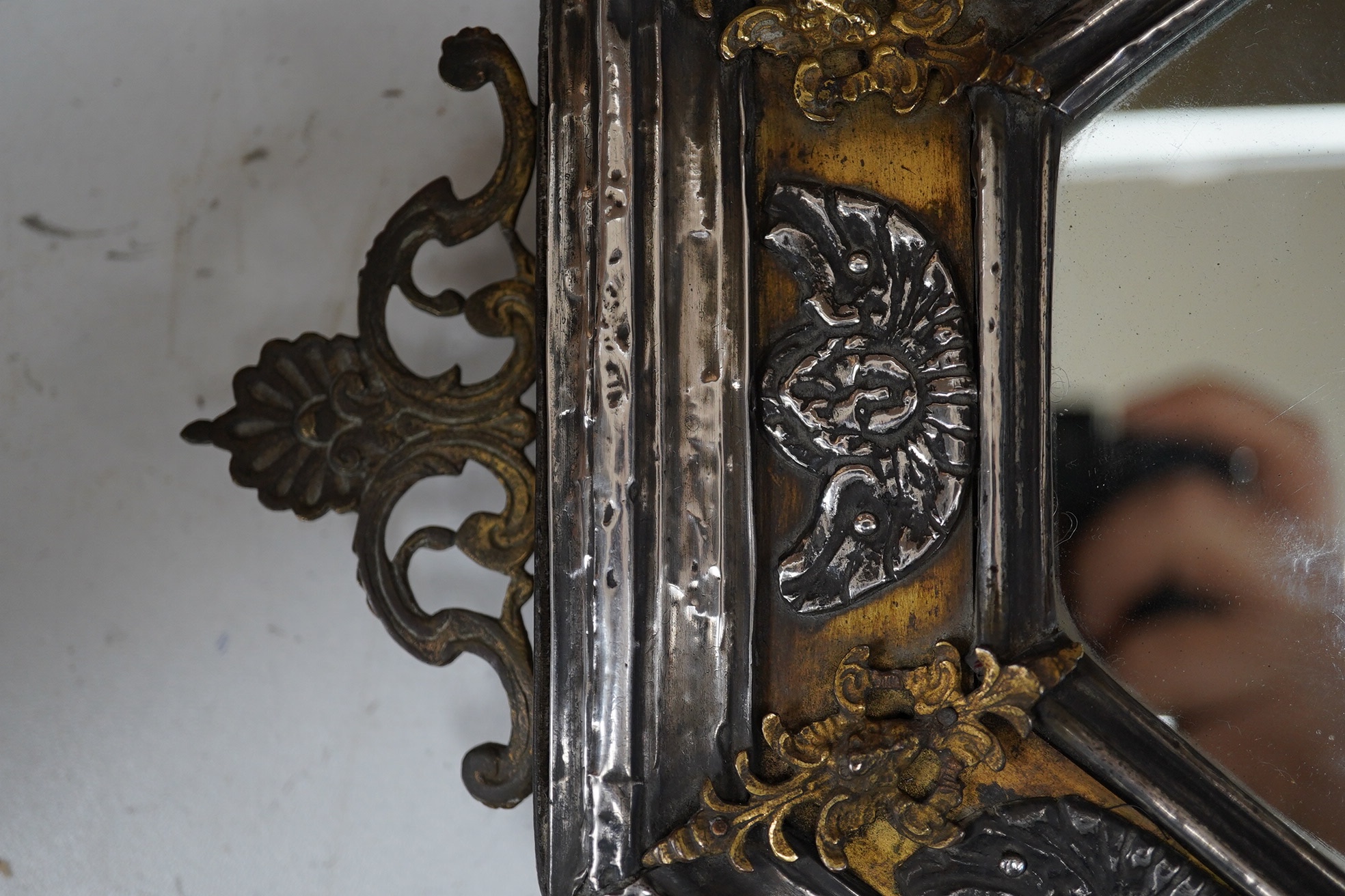 An octagonal white metal and brass mirror, 34cm wide. Condition - fair